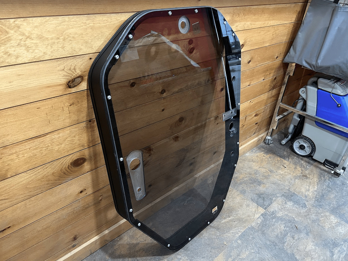 John Deere P Series tinted windshield frame assembly angled view showing red foam door seal strip