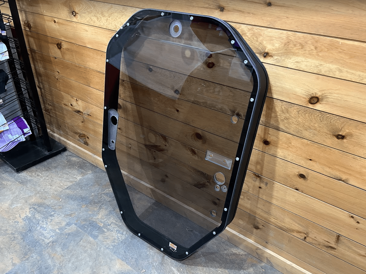 John Deere P Series tinted windshield frame assembly side view with latch hardware visible