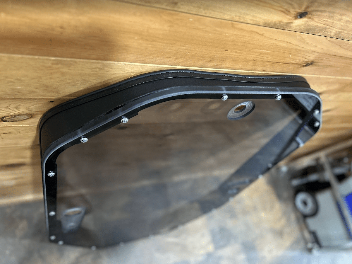Close-up of upper corner of tinted John Deere P Series windshield frame showing metal construction detail