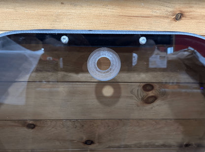Close-up of tinted John Deere P Series windshield frame top center showing mounting grommet and bolts