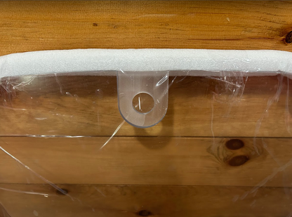 John Deere P Series windshield top edge showing white foam padding and hinge bracket with pin hole