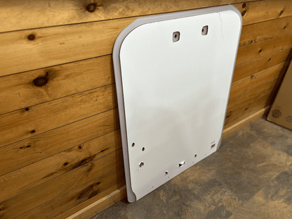 Kubota SSV polycarbonate windshield replacement panel leaning against a wood wall shown from a side angle