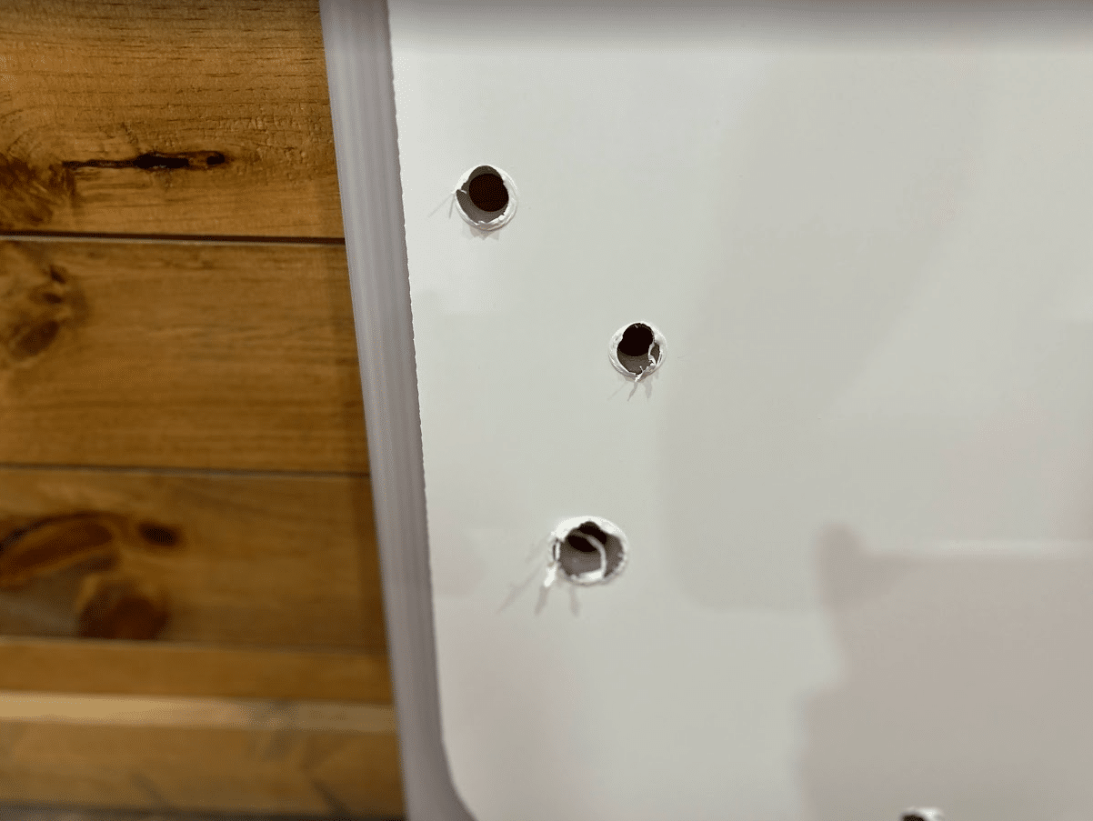 Close-up of the two top mounting holes on the Kubota SSV polycarbonate windshield panel for the metal fastening system