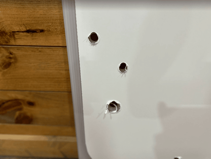 Close-up of the two top mounting holes on the Kubota SSV polycarbonate windshield panel for the metal fastening system