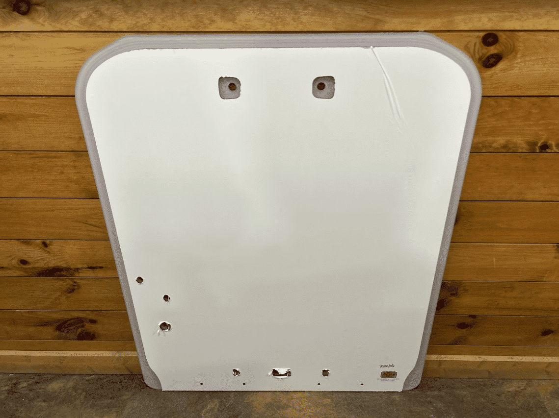 Kubota SSV65 and SSV75 skid steer polycarbonate windshield replacement panel shown from the front against a wood wall