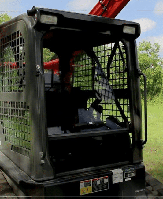 Kubota SVL compact track loader cab showing front windshield opening, machine outdoors in grassy area