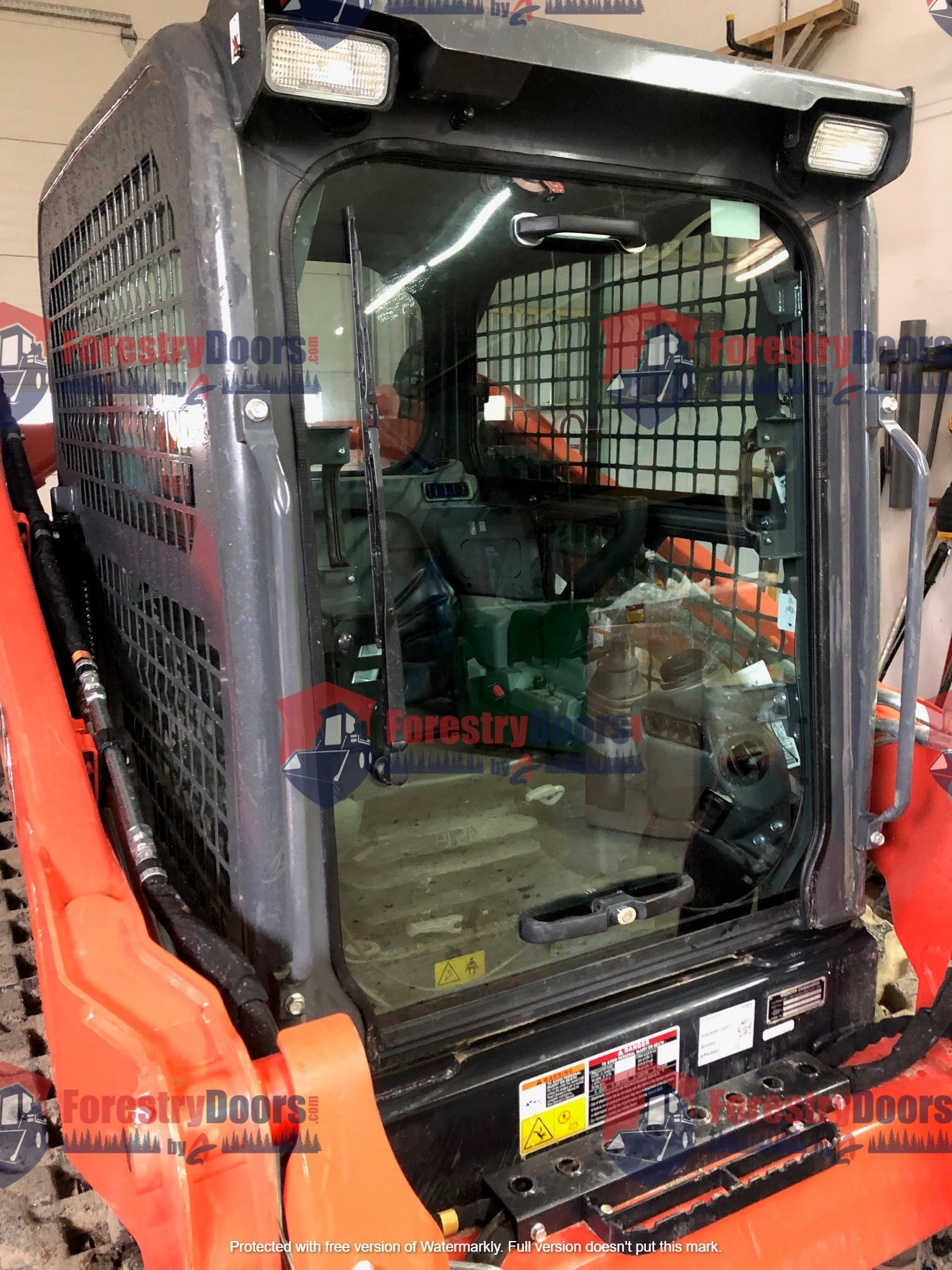 Kubota SVL compact track loader cab with door open showing front windshield area and interior