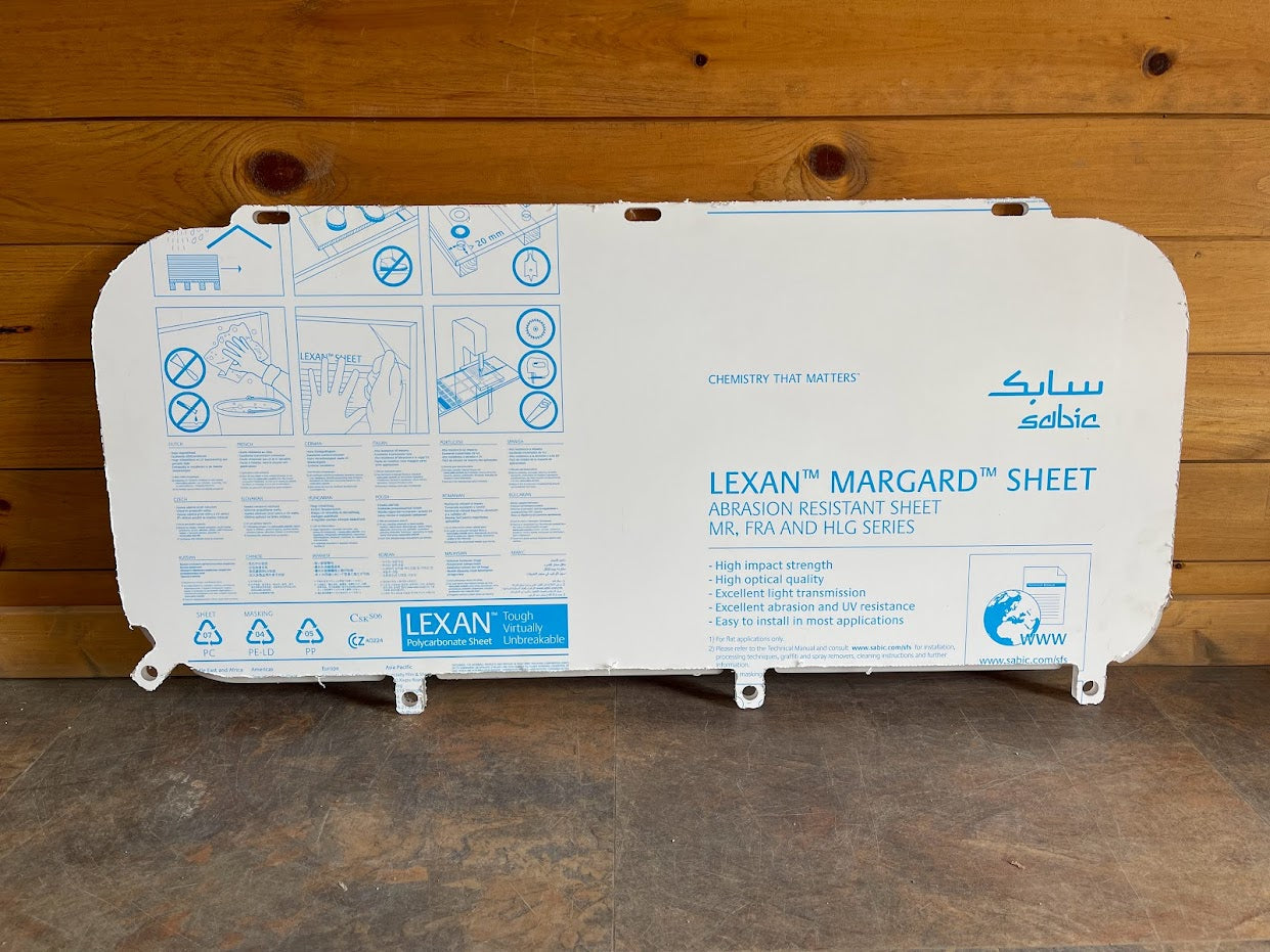 Back side of Kubota SVL polycarbonate side window showing Lexan Margard abrasion-resistant protective film with installation instructions