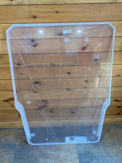 Takeuchi TL series polycarbonate windshield replacement panel with protective film standing upright against wood wall