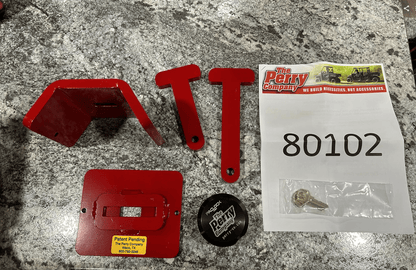 Trac-Lock anti-theft device components laid out showing red steel bracket, mounting arms, lock cap, key, and Perry Company label