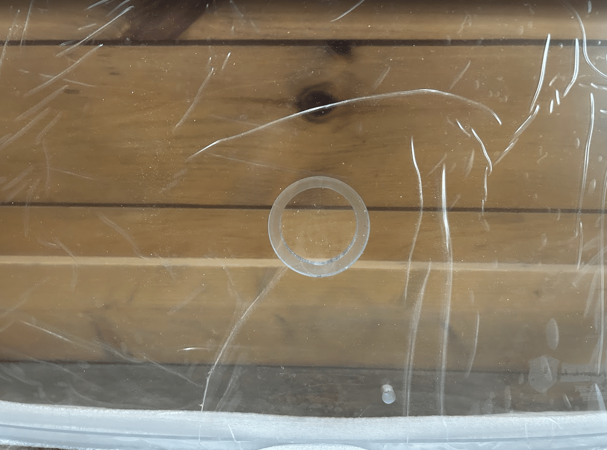 Close-up of circular wiper motor hole on Wacker Neuson ST/SW polycarbonate windshield surface